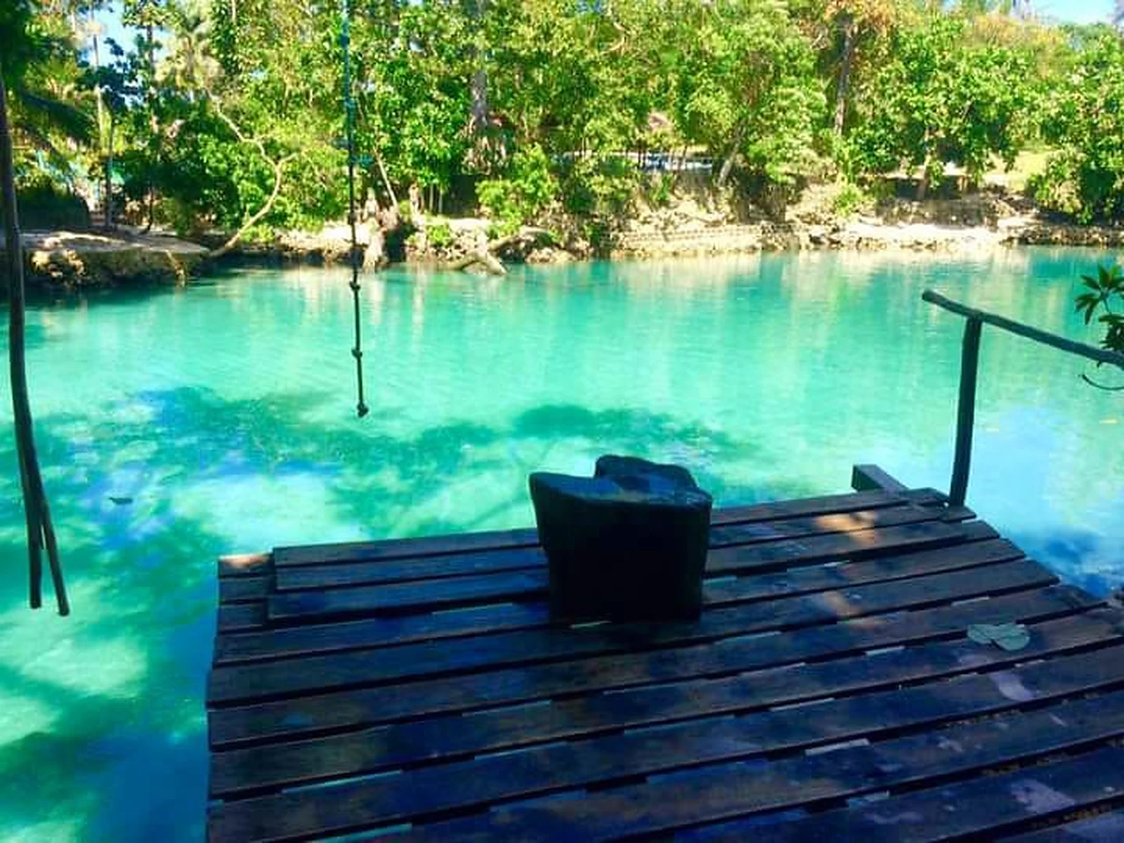 Clear blue lagoon surrounded by tropical greenery